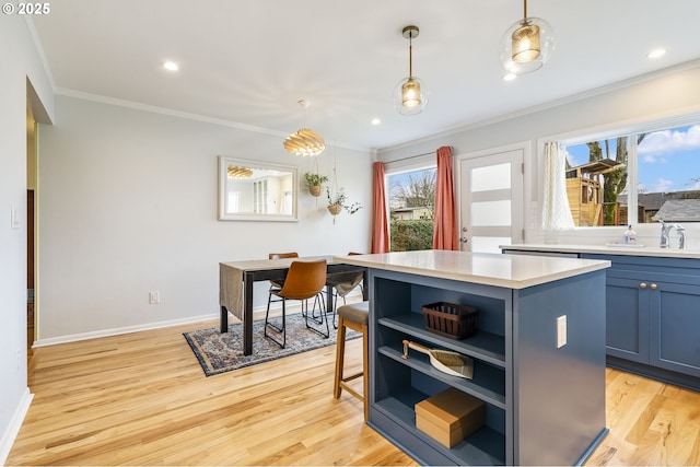 kitchen featuring a center island, pendant lighting, open shelves, light countertops, and a sink