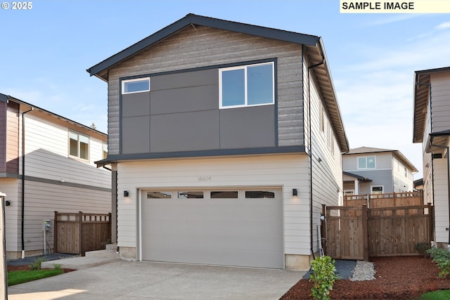 view of front facade featuring a garage, concrete driveway, and fence