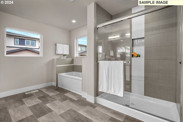 bathroom with visible vents, a stall shower, a bath, and baseboards