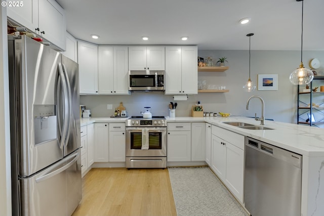 6825 SW Capitol Hill Rd Unit 27, Portland, OR 97219 - kitchen with stainless steel appliances, a peninsula, white cabinetry, and recessed lighting
