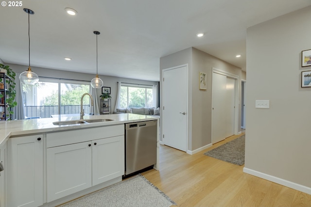 6825 SW Capitol Hill Rd Unit 27, Portland, OR 97219 - kitchen featuring dishwasher, light wood finished floors, light countertops, white cabinetry, and recessed lighting
