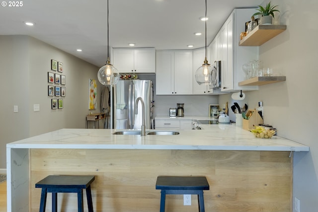 6825 SW Capitol Hill Rd Unit 27, Portland, OR 97219 - kitchen with open shelves, stainless steel refrigerator with ice dispenser, light stone countertops, a peninsula, and recessed lighting