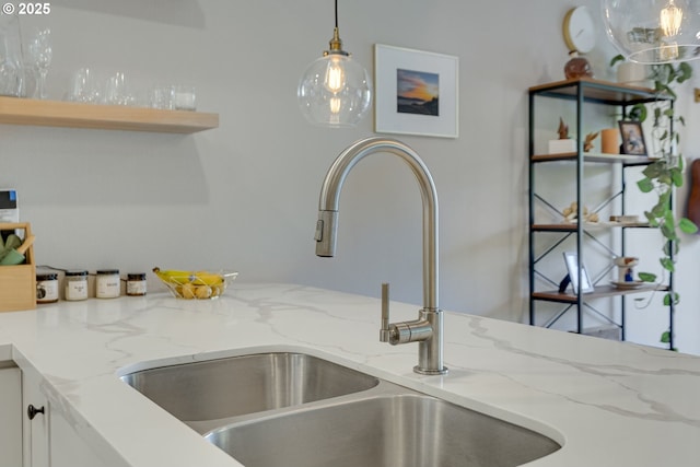 6825 SW Capitol Hill Rd Unit 27, Portland, OR 97219 - kitchen view of pendant lighting, white cabinets, light stone countertops, and open shelves