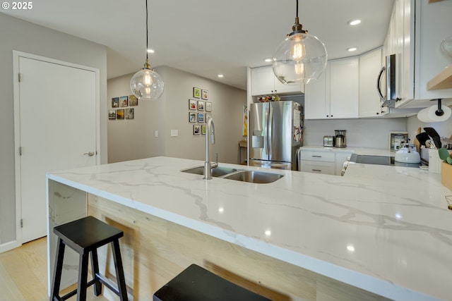 6825 SW Capitol Hill Rd Unit 27, Portland, OR 97219 - kitchen with stainless steel appliances, light stone countertops, a peninsula, recessed lighting, and hanging light fixtures