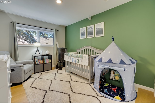 6825 SW Capitol Hill Rd Unit 27, Portland, OR 97219 - bedroom featuring wood finished floors and a nursery area