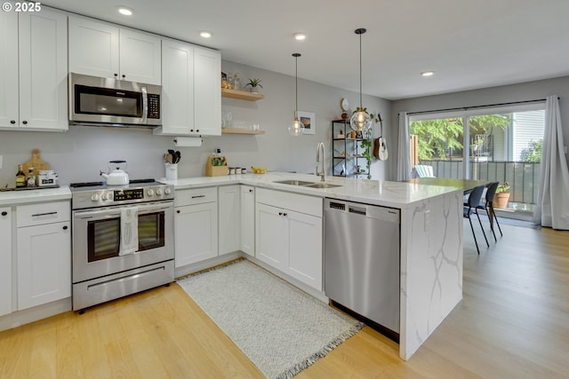 6825 SW Capitol Hill Rd Unit 27, Portland, OR 97219 - kitchen with appliances with stainless steel finishes, a peninsula, light wood finished floors, white cabinetry, and recessed lighting