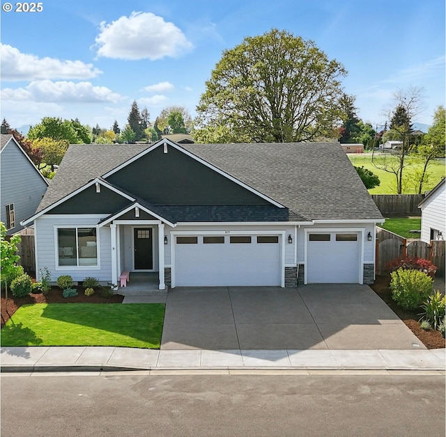 craftsman-style house with a front yard, a garage, a shingled roof, and fence