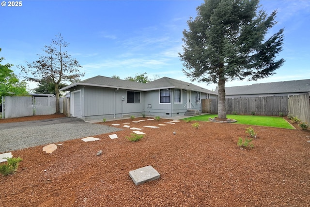 back of house featuring an attached garage, fence, a shingled roof, and gravel driveway