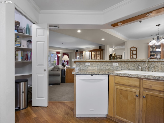 kitchen featuring crown molding, kitchen peninsula, white dishwasher, sink, and hardwood / wood-style flooring