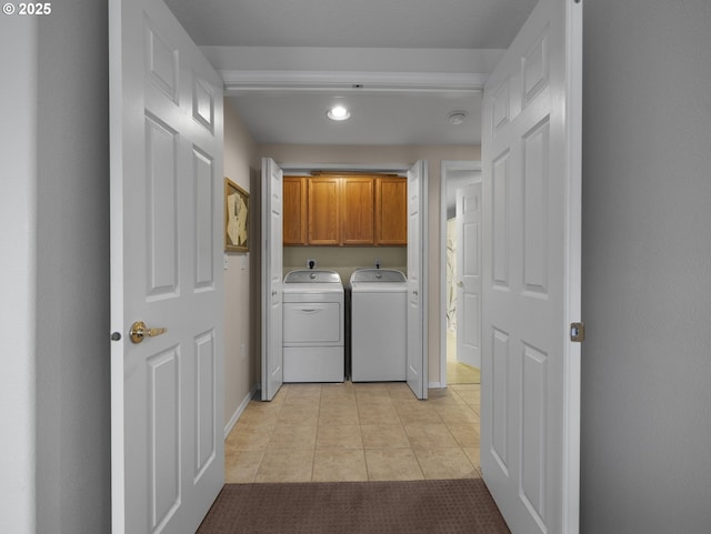 laundry room with independent washer and dryer, cabinets, and light tile patterned flooring