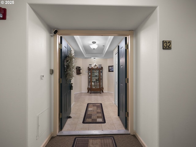 hall featuring ornamental molding and a raised ceiling