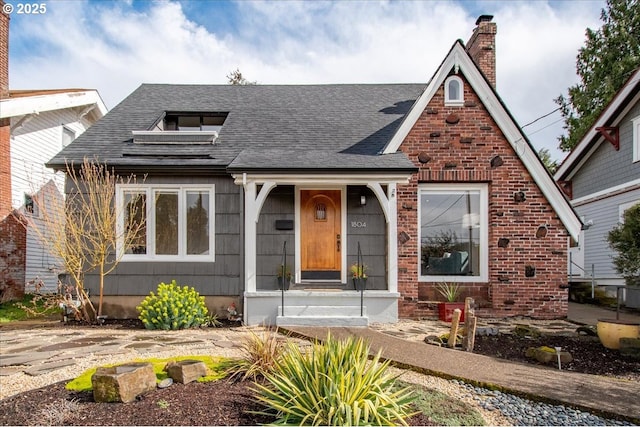 view of front of home with a chimney and a shingled roof