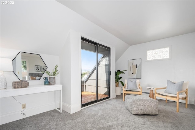 living area featuring lofted ceiling and carpet