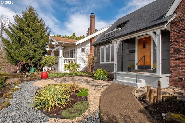 back of property featuring a chimney and a shingled roof