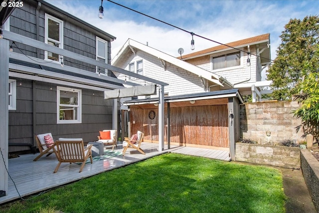 back of property featuring fence, a lawn, a pergola, and a wooden deck