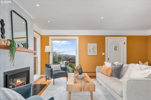 living room with recessed lighting, a large fireplace, and wood finished floors