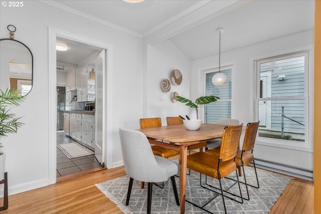 dining room featuring crown molding, light wood-type flooring, a baseboard heating unit, and baseboards