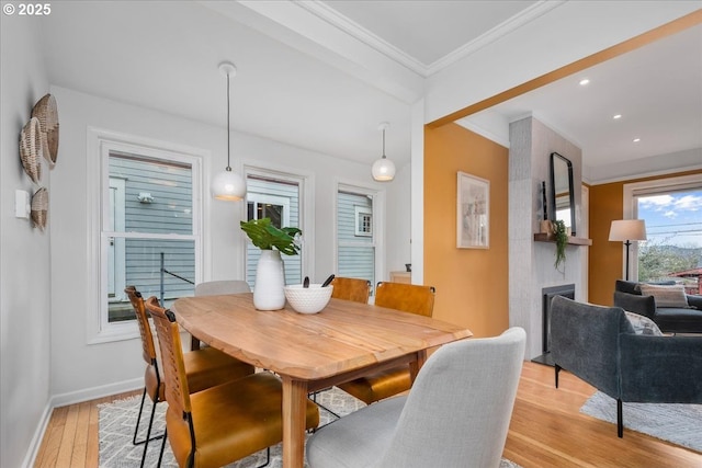 dining room featuring recessed lighting, crown molding, light wood-type flooring, and baseboards