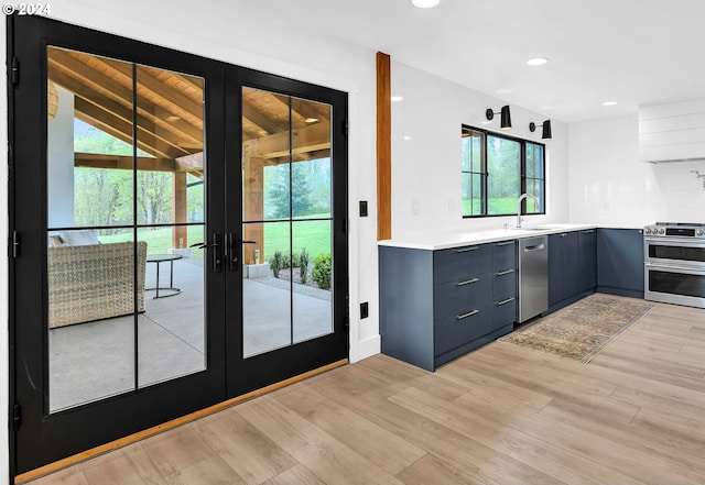 entryway with light wood-type flooring, french doors, a sink, and recessed lighting