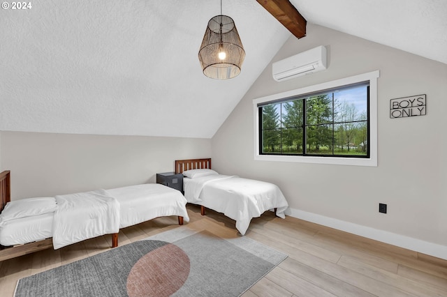 bedroom with vaulted ceiling with beams, a wall mounted AC, a textured ceiling, wood finished floors, and baseboards