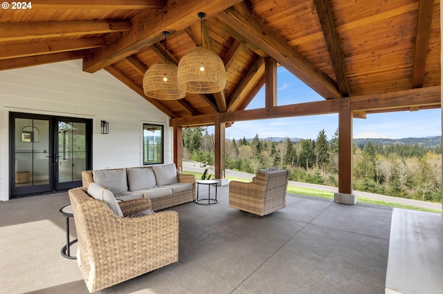 view of patio with an outdoor living space, a view of trees, and french doors