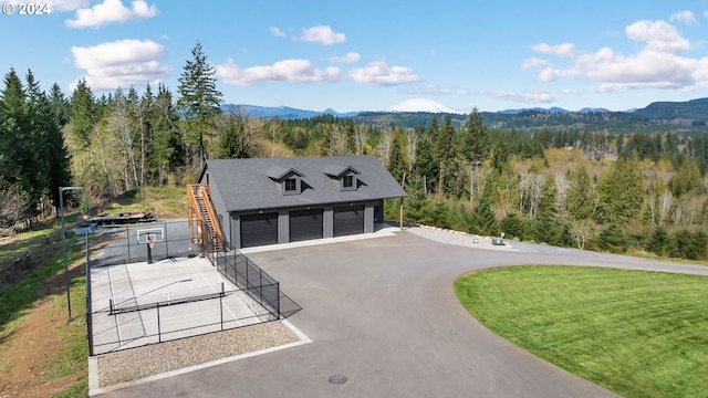 exterior space with a mountain view, driveway, and a wooded view