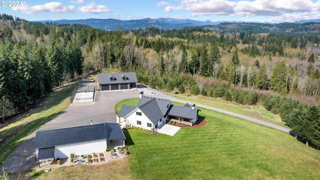 birds eye view of property with a mountain view and a forest view