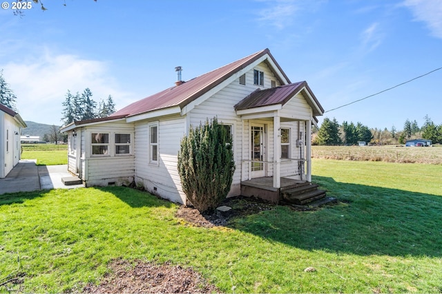 bungalow-style house with a front yard, crawl space, and metal roof