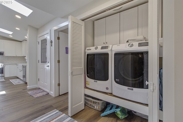 9403 SW 74th Ave, Portland, OR 97223 - laundry room featuring washing machine and dryer, a skylight, light wood-type flooring, cabinet space, and recessed lighting