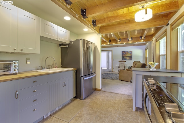 9403 SW 74th Ave, Portland, OR 97223 - kitchen featuring a wooden ceiling with exposed beams, freestanding refrigerator, light carpet, open floor plan, and white cabinetry