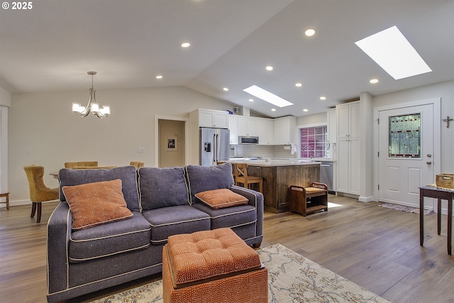 9403 SW 74th Ave, Portland, OR 97223 - living area featuring a skylight, a chandelier, lofted ceiling, light wood-style flooring, and recessed lighting