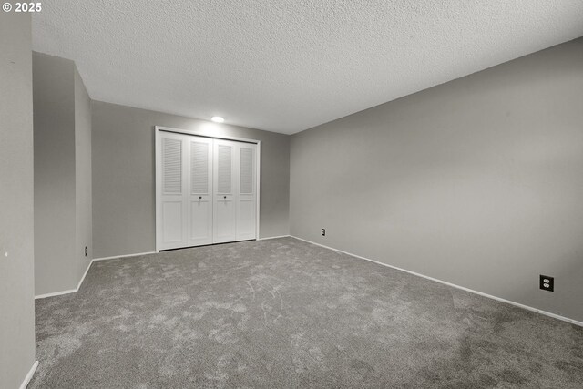 unfurnished bedroom featuring carpet flooring, a textured ceiling, and a closet