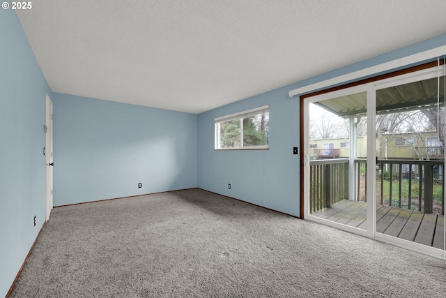 empty room with a textured ceiling and carpet floors