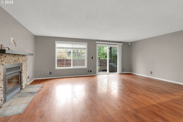 unfurnished living room with a textured ceiling and light wood-type flooring