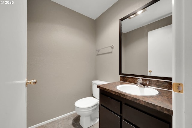 bathroom with tile patterned flooring, vanity, and toilet