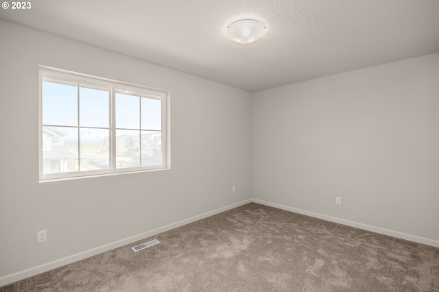 empty room featuring carpet and a textured ceiling