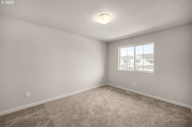 carpeted empty room with a textured ceiling