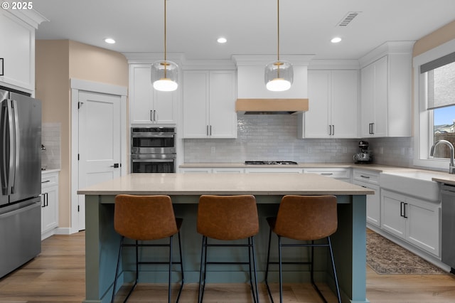 3838 SE 7th Ave, Battle Ground, WA 98604 - kitchen featuring stainless steel appliances, a sink, custom exhaust hood, tasteful backsplash, and white cabinetry