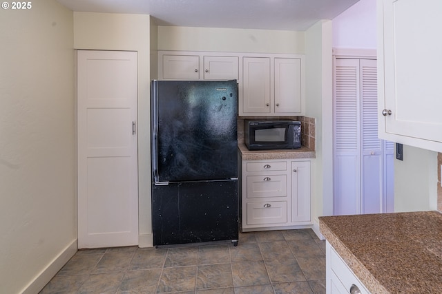 kitchen with black appliances, white cabinetry, and baseboards