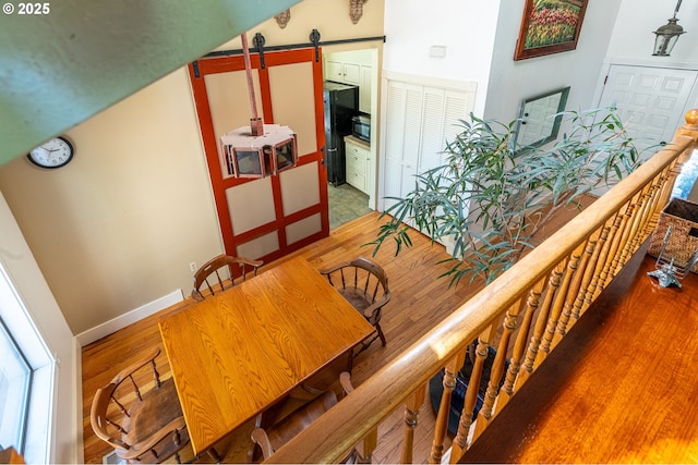 interior space featuring wood finished floors, a barn door, and baseboards