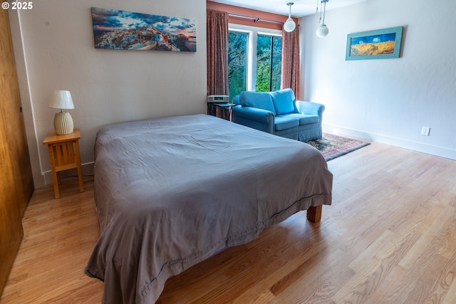 bedroom with light wood-style flooring and baseboards