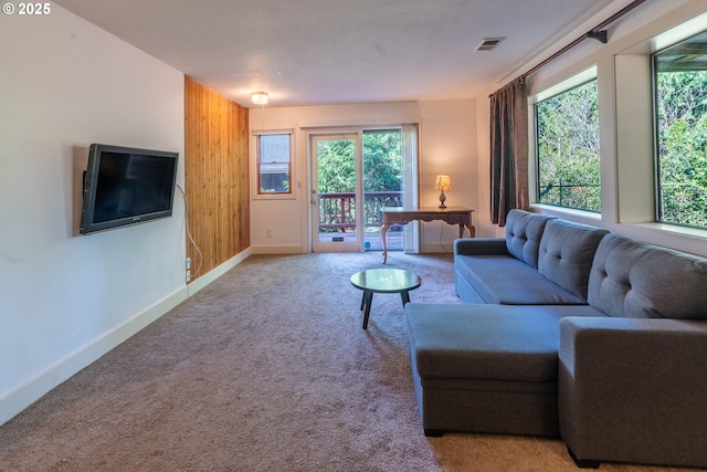 living area with visible vents, light carpet, and baseboards