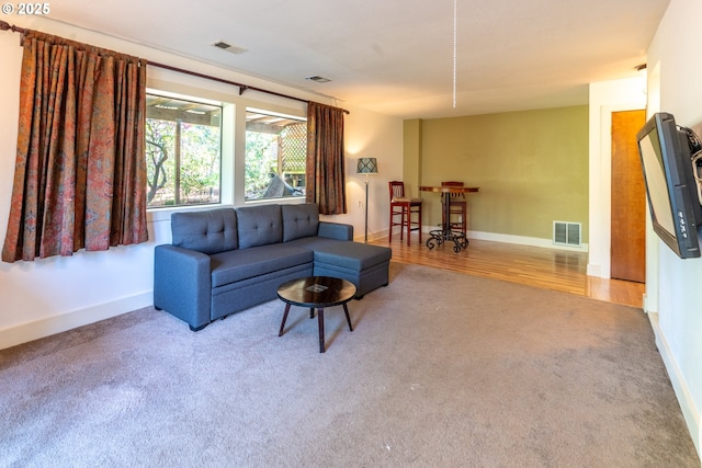 living room featuring visible vents, baseboards, and carpet floors