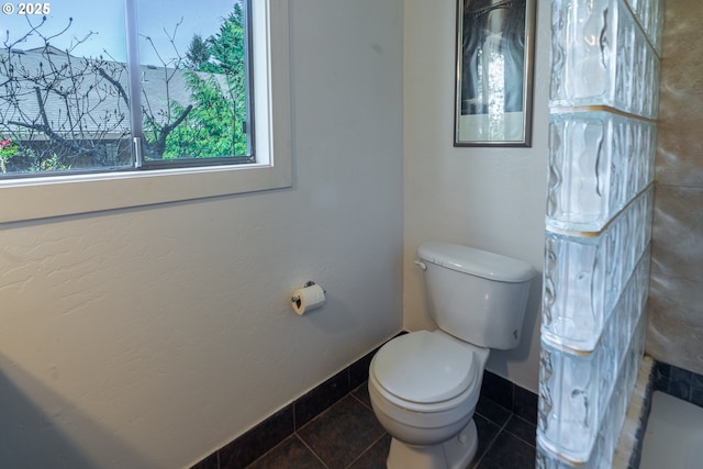 bathroom featuring toilet, tile patterned flooring, and baseboards