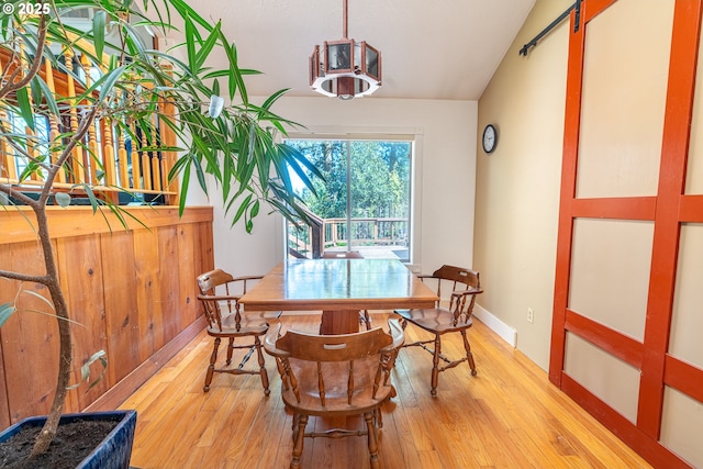 dining room with lofted ceiling and light wood-style floors