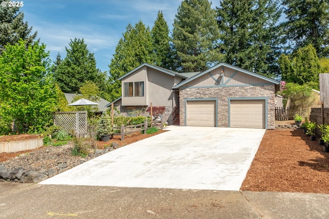 view of front facade with an attached garage, fence, concrete driveway, and stone siding