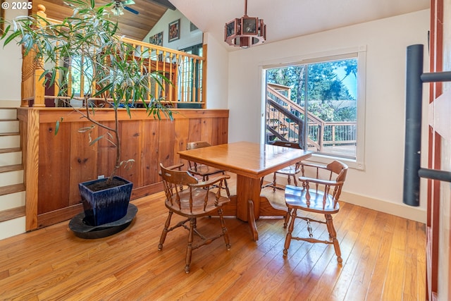 dining space featuring lofted ceiling, stairway, light wood-style flooring, and baseboards