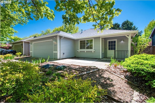 rear view of house with a garage, fence, and roof with shingles