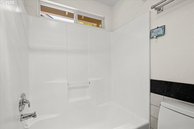 bathroom with toilet and  shower combination