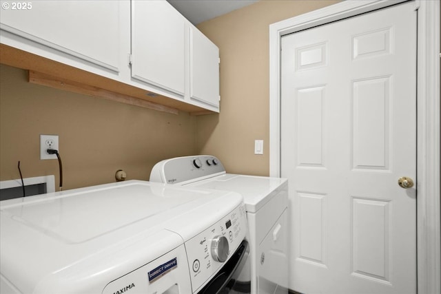 washroom with washer and clothes dryer and cabinet space